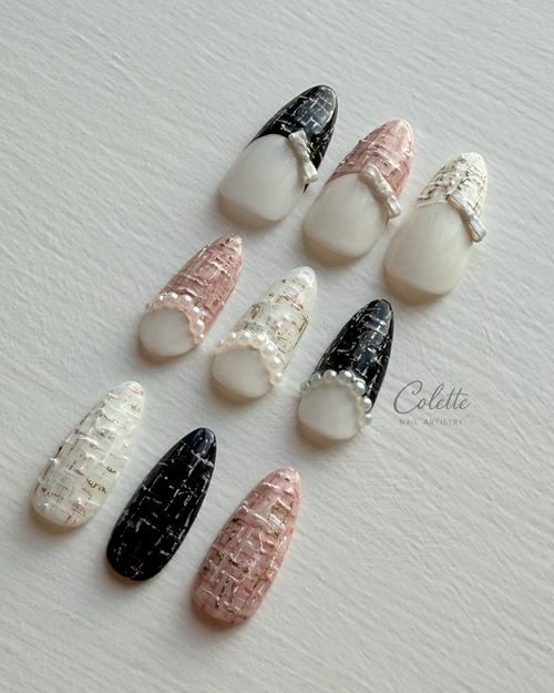 Tweed Glow press-on nails in black, soft pink and white with textured tweed detailing, pearl accents and 3D bow.