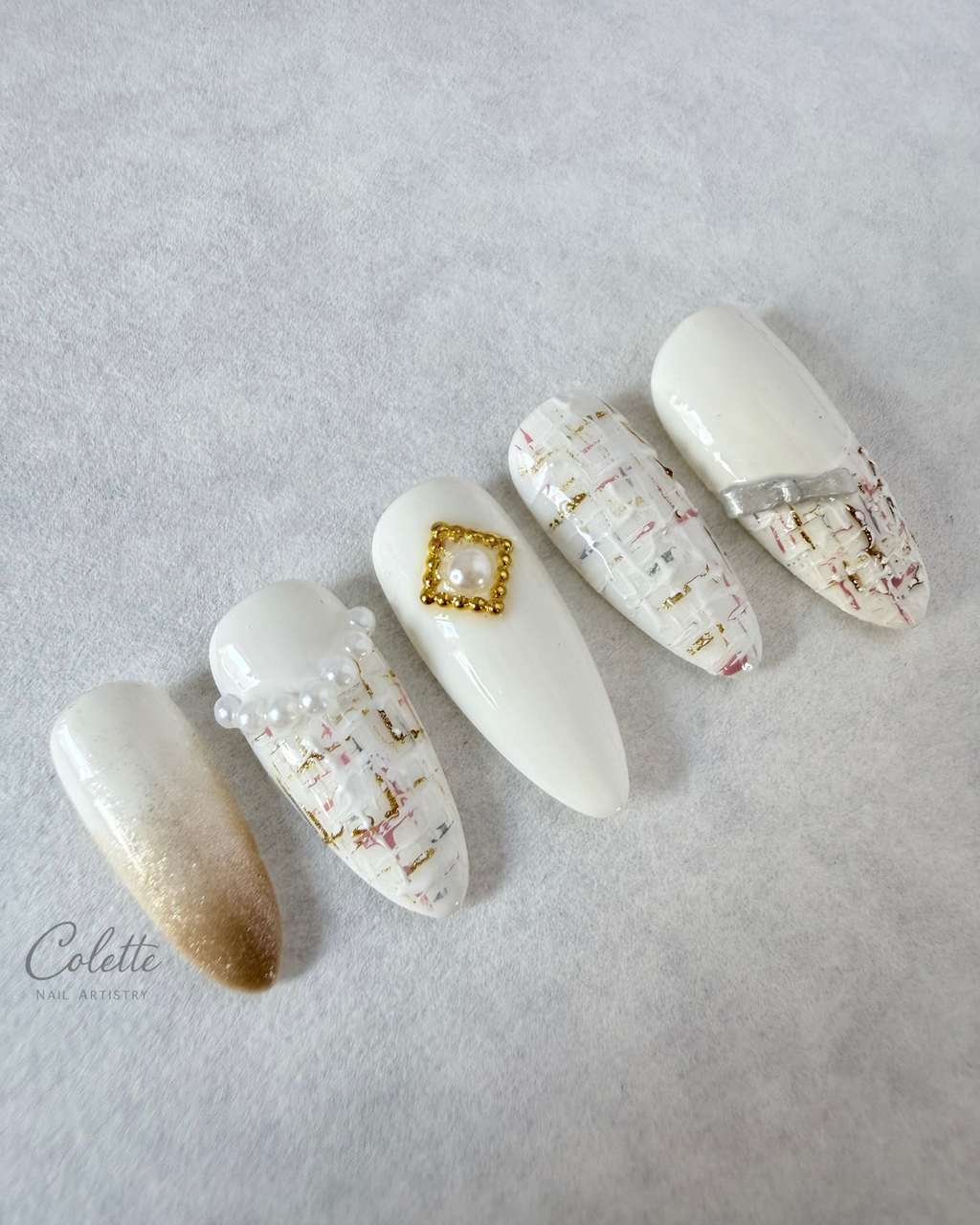 Tweed Glow press-on nails in gold and white with textured tweed detailing, 3D bow and pearl accents.